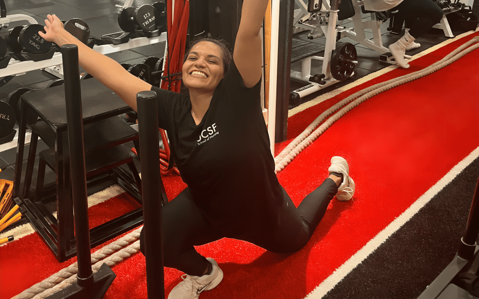 Woman smiling and posing in a gym.