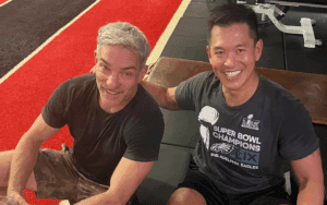 Two men smiling at the gym floor.