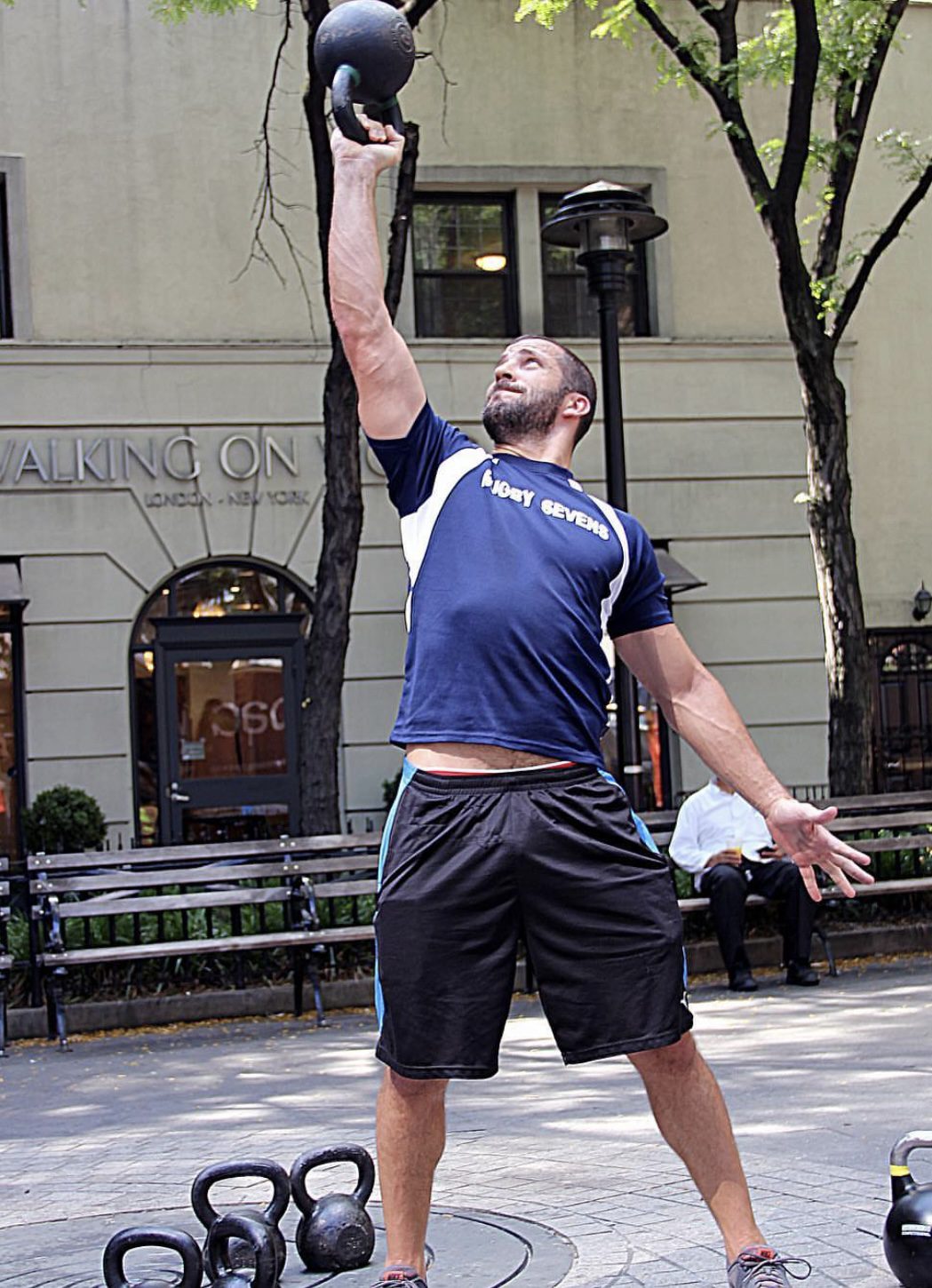 Man in sportswear preparing to serve a tennis ball outdoors.